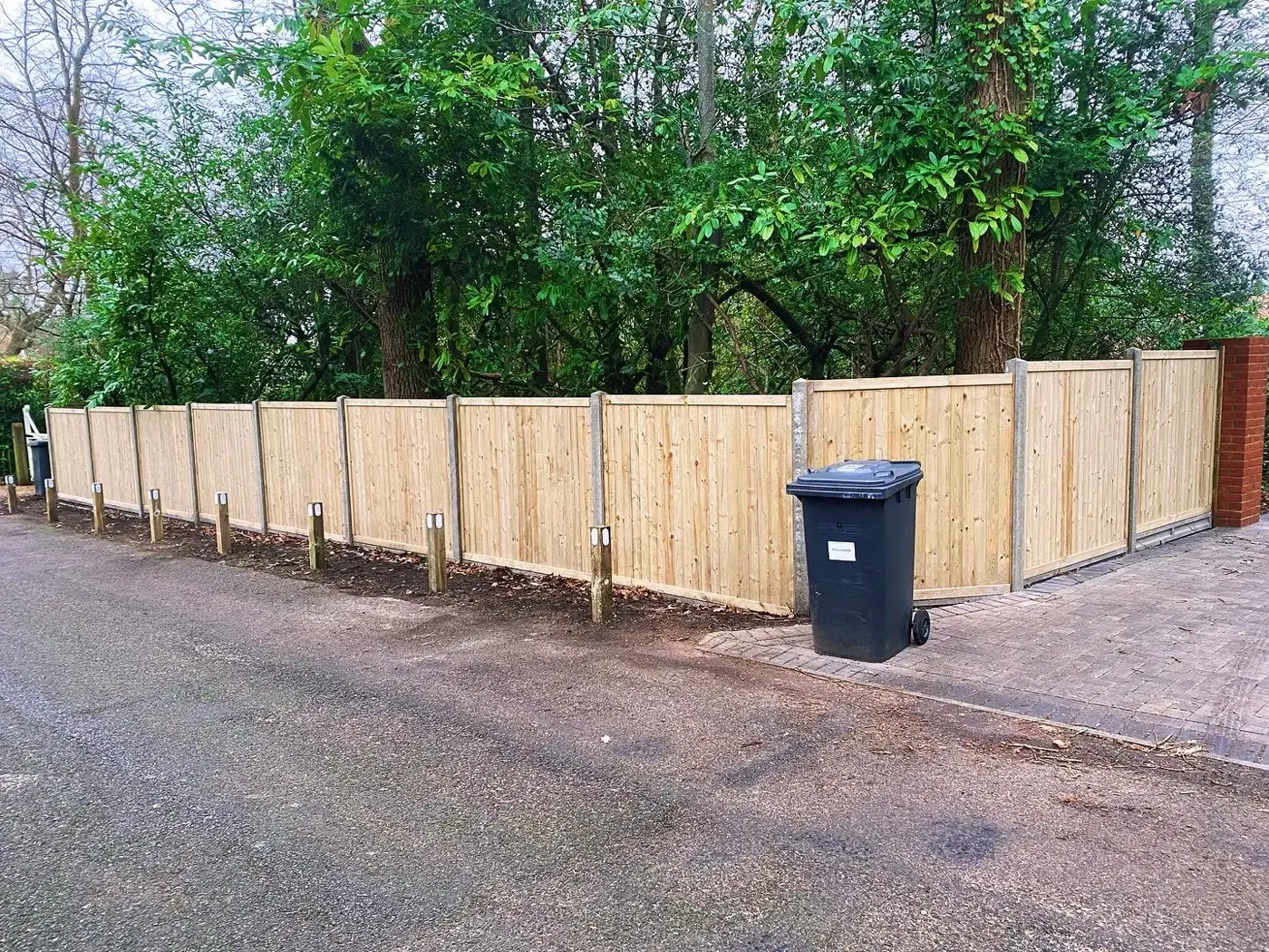 Closeboard fence installation with concrete posts and gravel boards